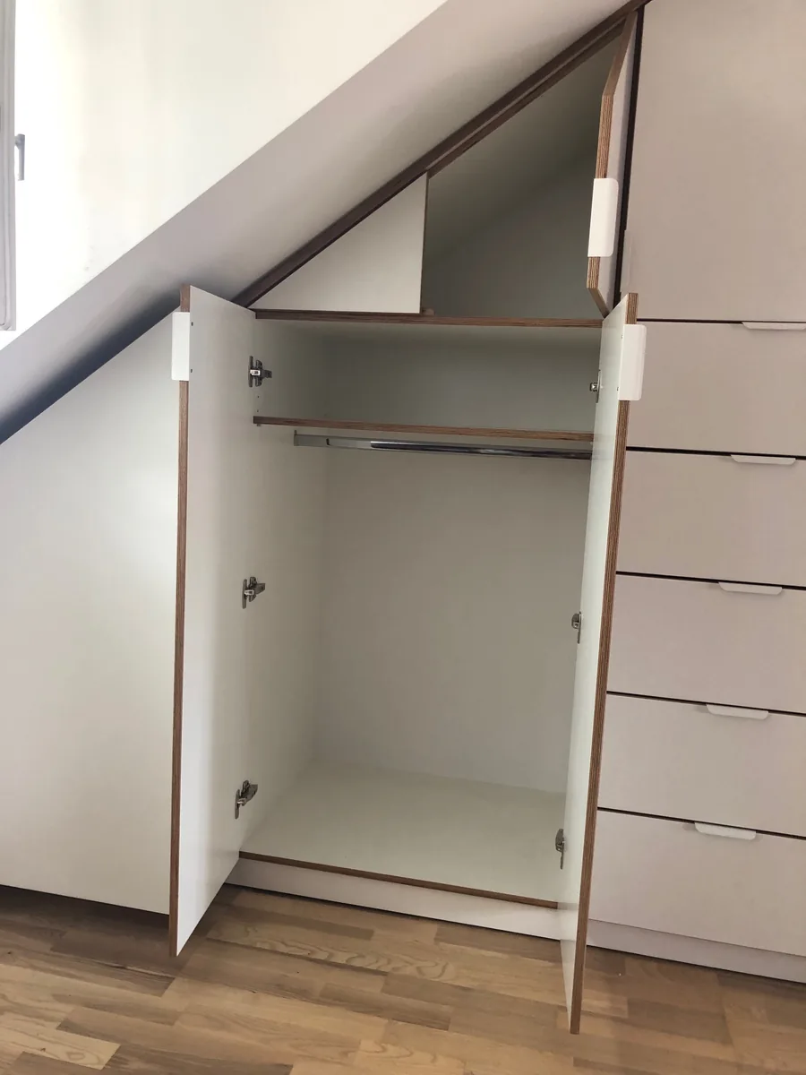 Der geöffnete Schrank von vorn: eine Kleiderstange über die volle Breite, rechts daneben ein Stapel Schubkästen.
