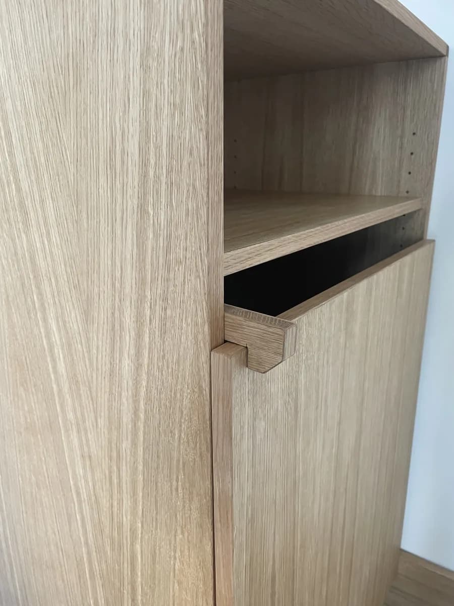 Detail am Truhenregal aus Eiche: der Holzhaken, der die Klappe arretiert, darüber ein Regalboden.